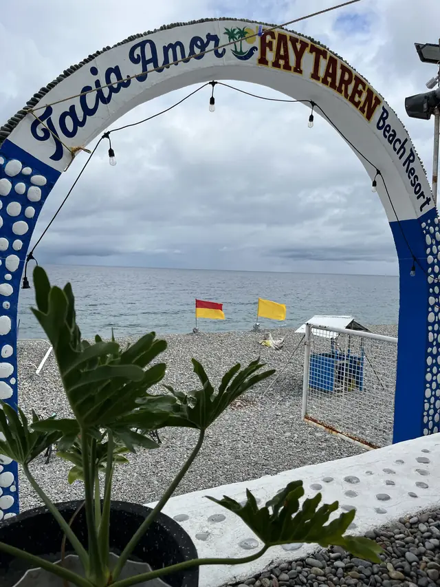 Entrance arch framing the sea and the pebble beach