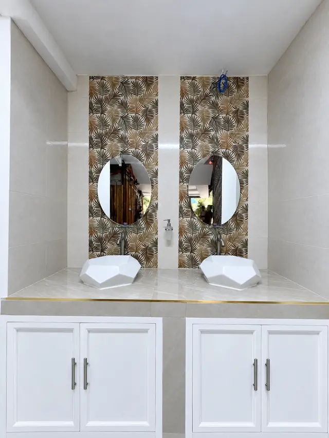 Common washroom with two sinks and round mirrors