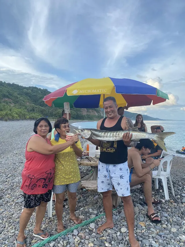 Guests holding a fresh catch on the beach